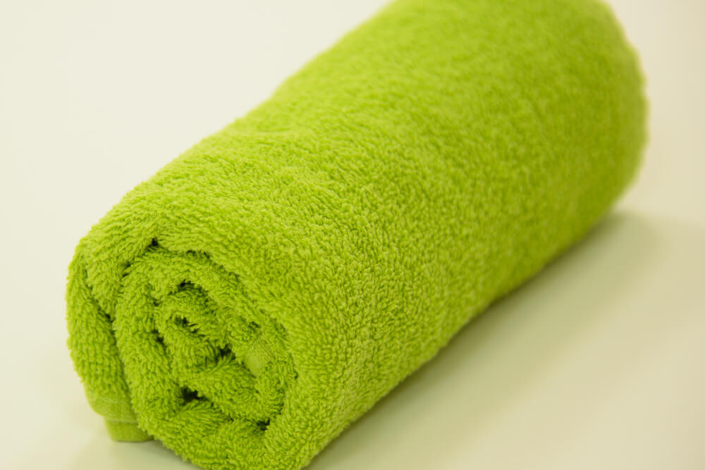 Grünes Handtuch, das mit kochendem Wasser getränkt und für die Wärmebehandlung bei Patienten genutzt wird.
